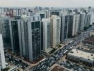 Investir em Imóveis no DF: Por Que as Regiões Fora do Plano Piloto Continuam Sendo Uma Opção Inteligente em 2026? 3 Vista aérea panorâmica de edifícios residenciais e comerciais em área urbana densa, ilustrando oportunidades para quem deseja investir em imóveis no DF