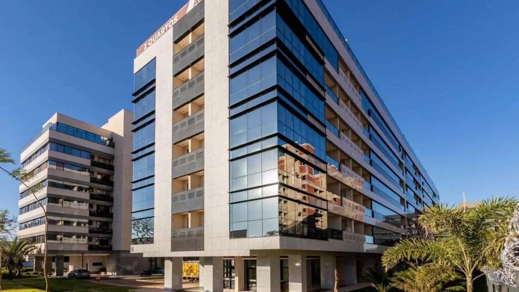 Fachada moderna de prédio residencial revestida em vidro e granito, destacando unidades de apartamento 2 quartos Noroeste em Brasília.