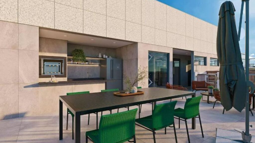 Lounge gourmet na cobertura com área coberta e cortina de vidro, churrasqueira, mesa de jantar com cadeiras verdes e área de estar externa em um Apartamento 3 Quartos Noroeste - Residencial Yard em Brasília.